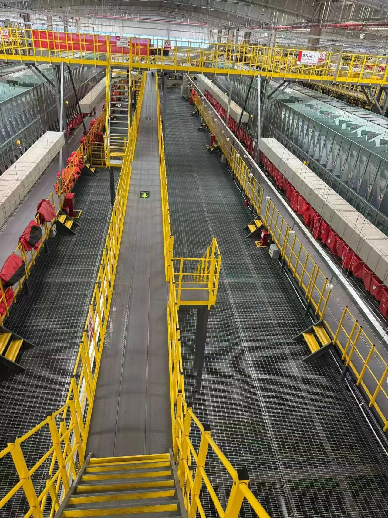 Steel grating access routes beside sorting lines with yellow guardrails and stair connections
